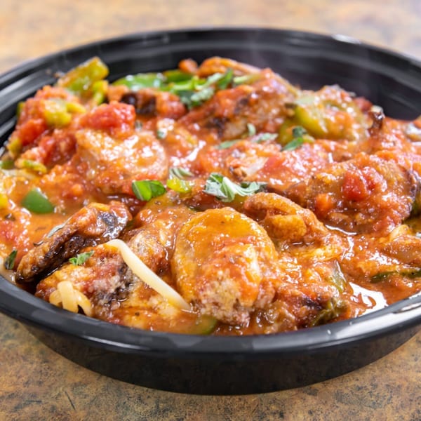 Midways De La Roma's Italian sausage and peppers in a rich tomato sauce, garnished with fresh basil.