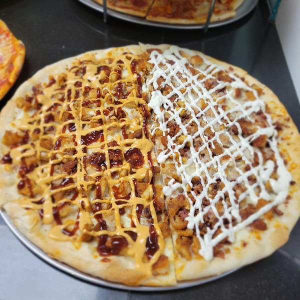 Midways De La Roma's half BBQ chicken and half ranch chicken pizza on a metal tray.