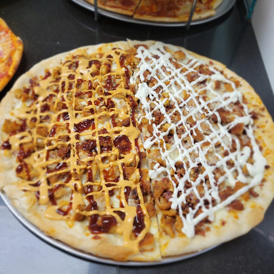 Midways De La Roma's half BBQ chicken and half ranch chicken pizza on a metal tray.