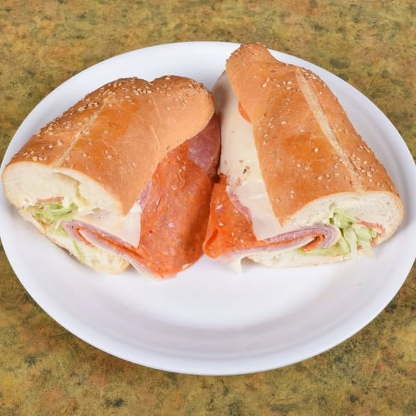 Two halves of a Midways De La Roma Italian sub sandwich with meats, cheese, and lettuce.